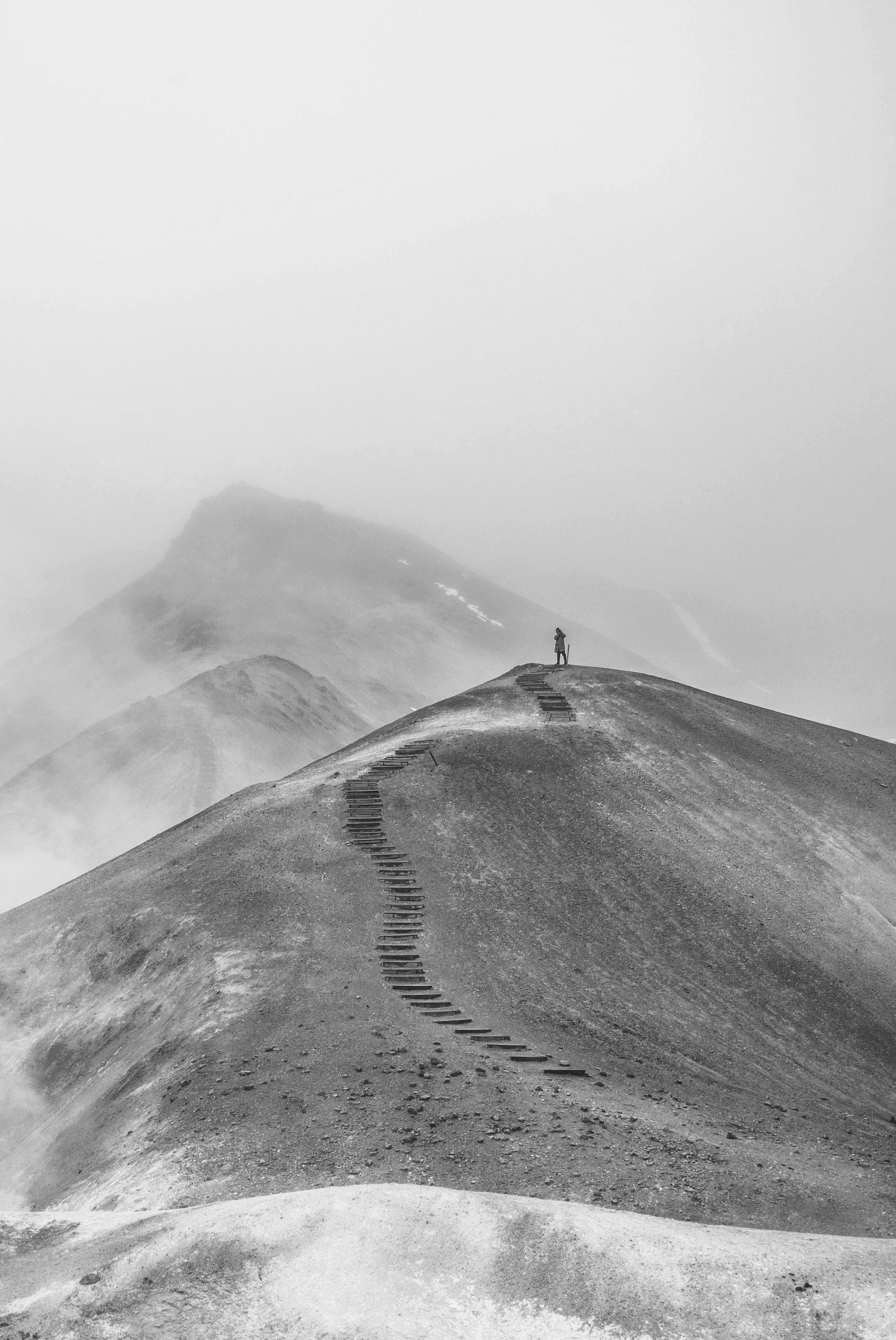 Background image of person walking up path on a mountain